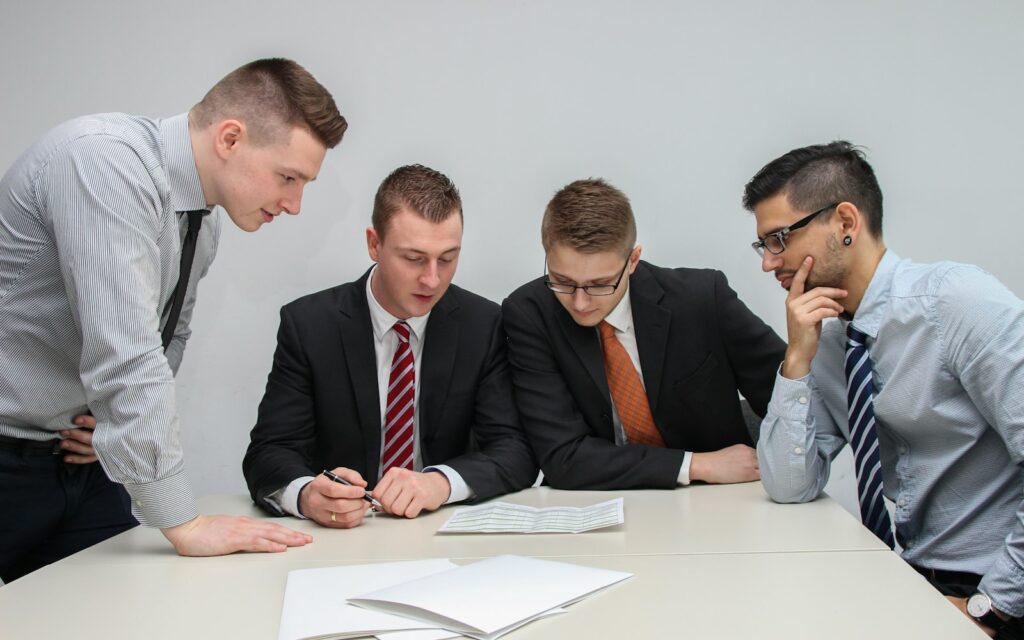 Vier Personen besprechen Unterlagen am Tisch und planen das Change-Management für KI