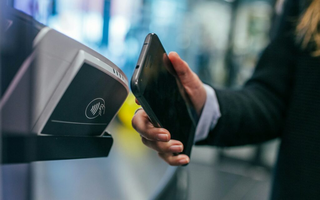 Person nutzt Banking-App auf dem Smartphone, Transaktion wird per KI-Betrugserkennung geprüft