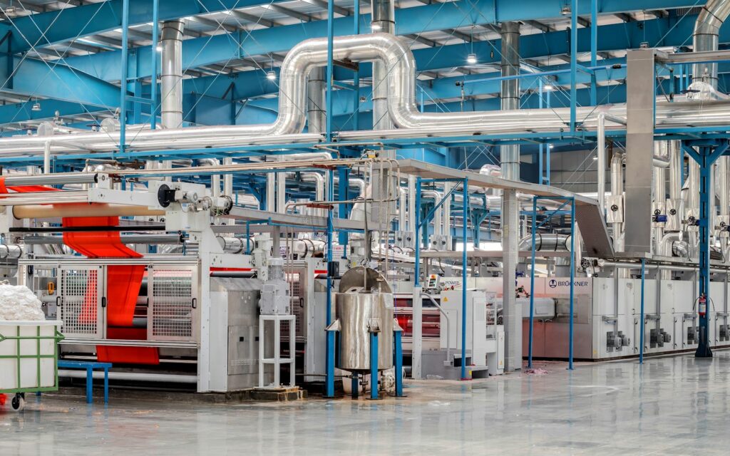 Produktionsanlage mit Maschinen und Rohren, überwacht durch Predictive Maintenance