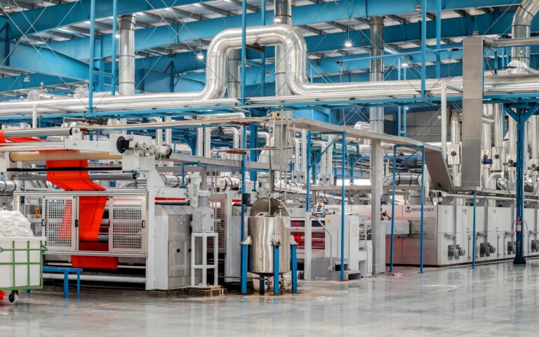 Produktionsanlage mit Maschinen und Rohren, überwacht durch Predictive Maintenance