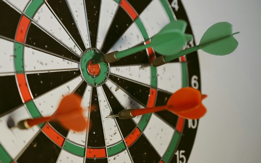 Dartscheibe mit Pfeilen im Zentrum als Symbol für Ziele mit OKR und Zielvereinbarung