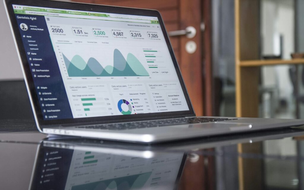 Laptop mit Diagrammen auf einem Glastisch zur Analyse der SaaS-Preisstrategie