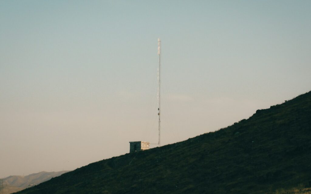 Funkturm auf einem Hügel bei Sonnenuntergang: Satelliten-Internet für Unternehmen in ländlichen Regionen