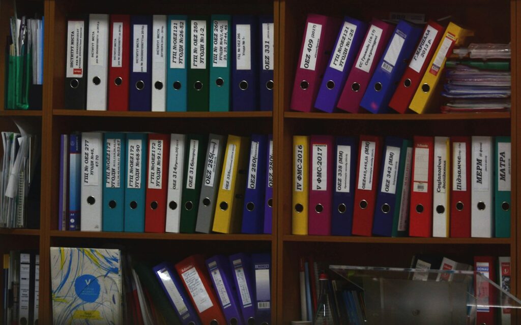 Bunte Ordner in einem Büroregal, Symbolbild zu Aufbewahrungsfrist Buchungsbelege