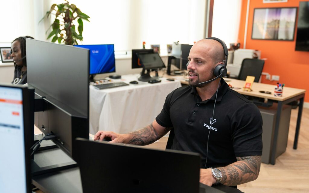 IT-Support-Mitarbeiter mit Headset am Computer, Symbolbild zu Copilot im Unternehmen