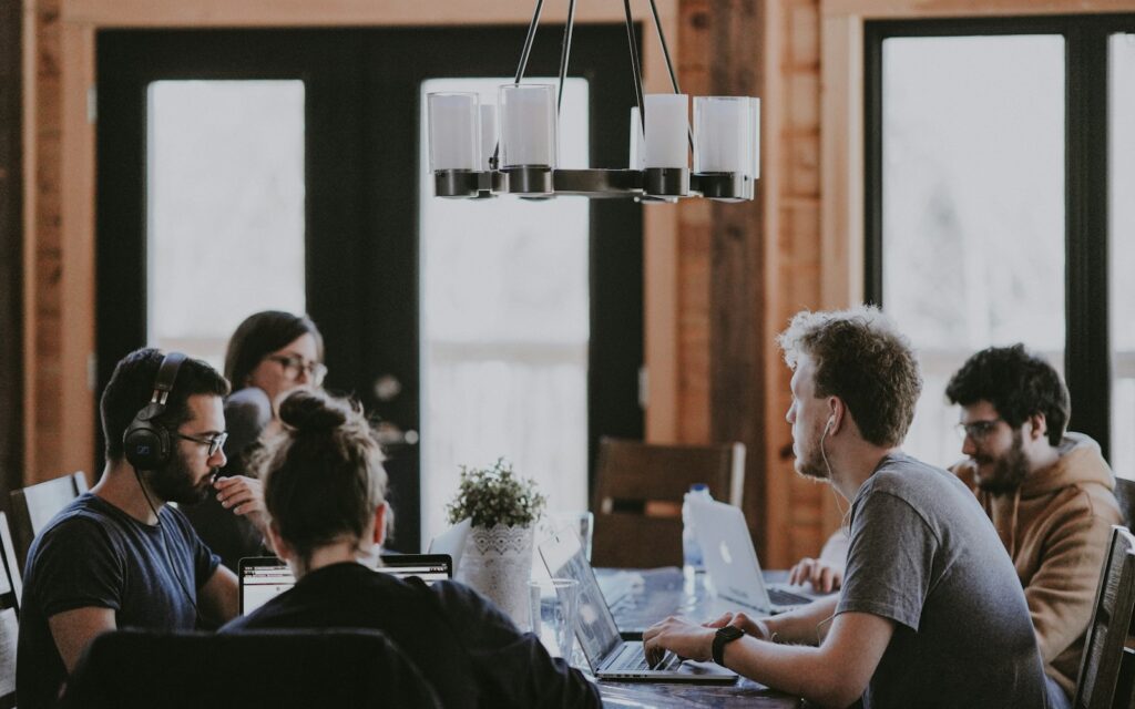 Team bespricht am Tisch die Datenstrategie: Datenökonomie beginnt mit gemeinsamer Bewertung der Daten