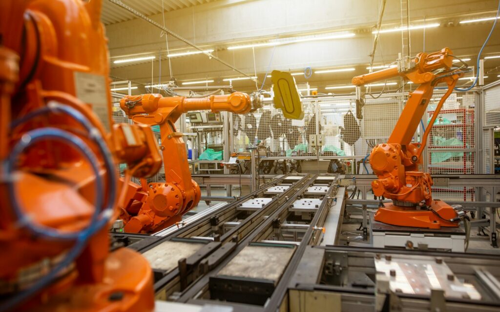 Industrieroboter in einer Fabrikhalle als Symbol für KI im Mittelstand