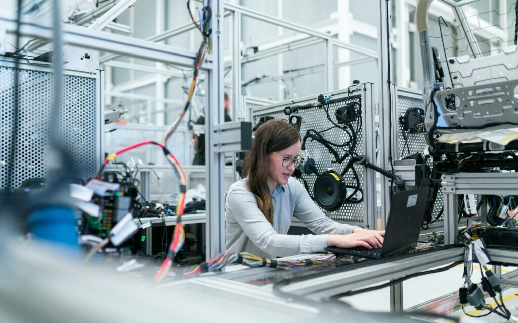 Ingenieurin mit Laptop in der Fertigung treibt die digitale Transformation im Mittelstand voran