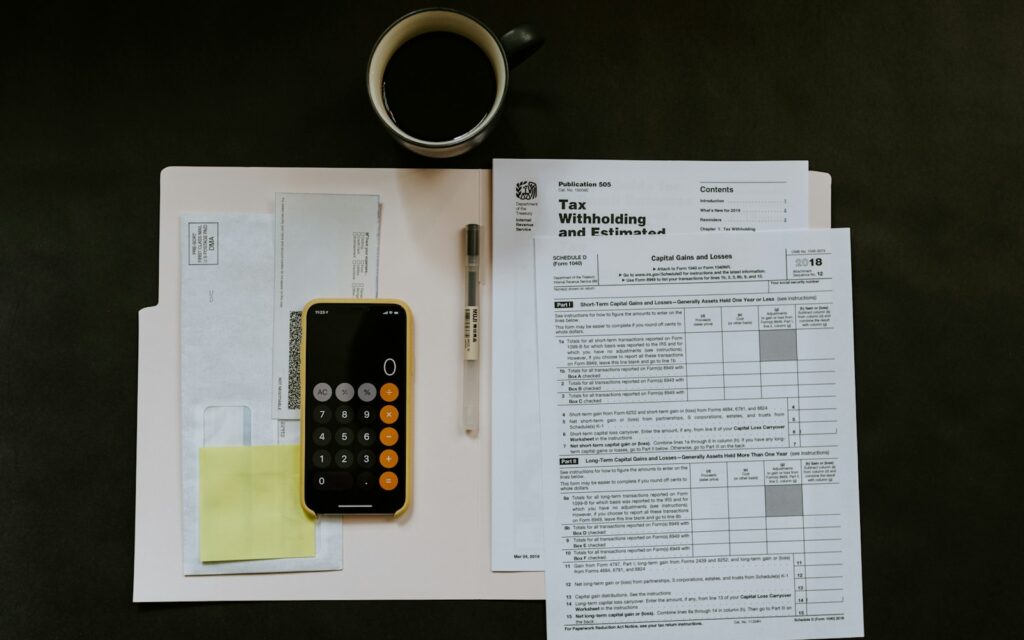 Steuerunterlagen, Smartphone und Stift, Symbolbild zu Digitale Wirtschaftsgüter Abschreibung