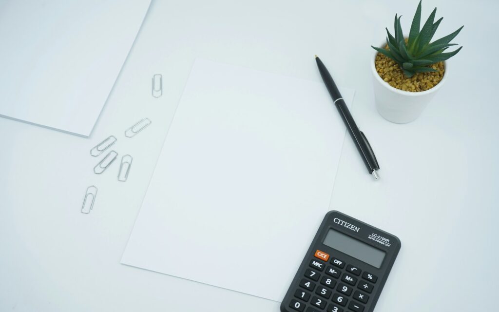 Taschenrechner und Stift auf Unterlagen, Symbolbild zu E-Rechnung Pflicht 2027