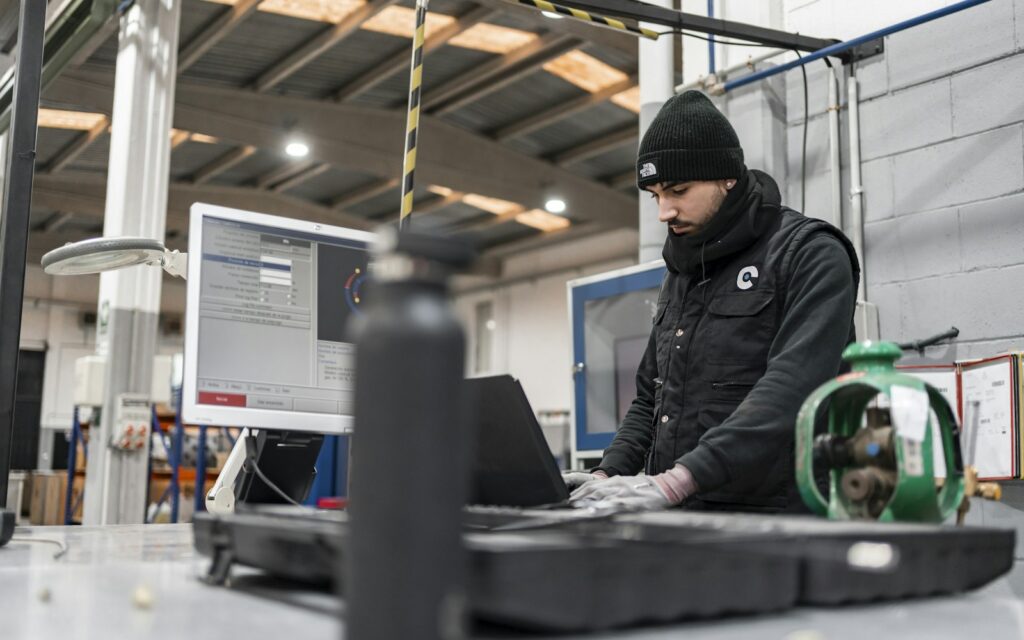 Mitarbeiter arbeitet an einem Computer in einer Produktionsumgebung, Symbolbild zu Edge Computing