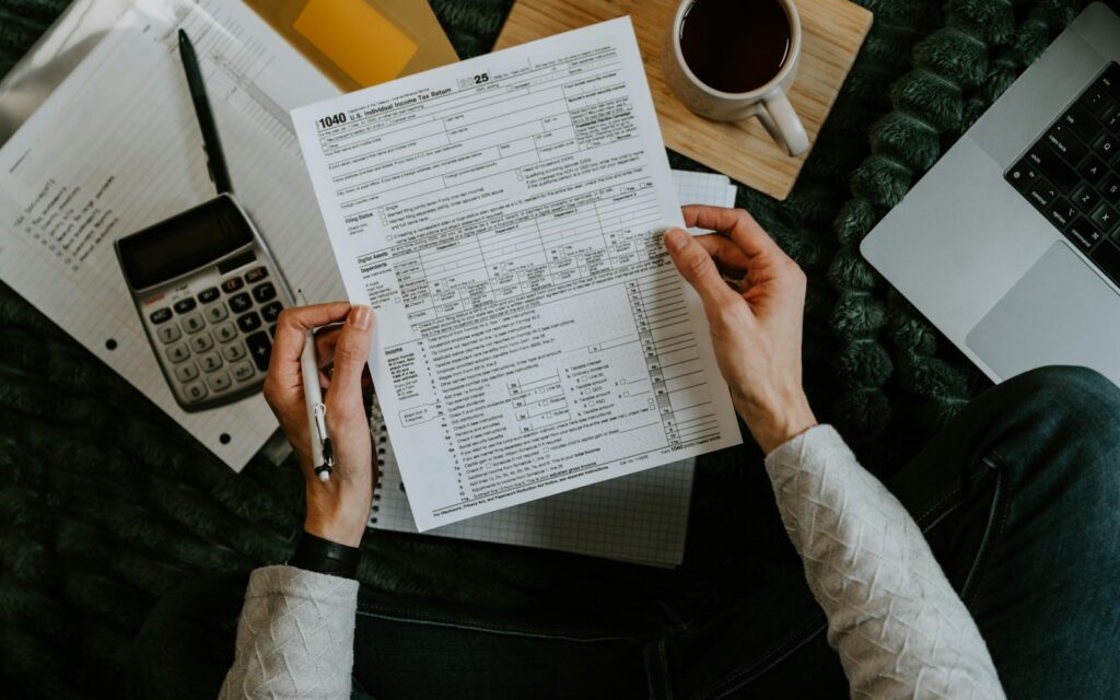 Hände vergleichen Unterlagen mit Taschenrechner und Laptop, Symbolbild zu Entscheidungsmatrix
