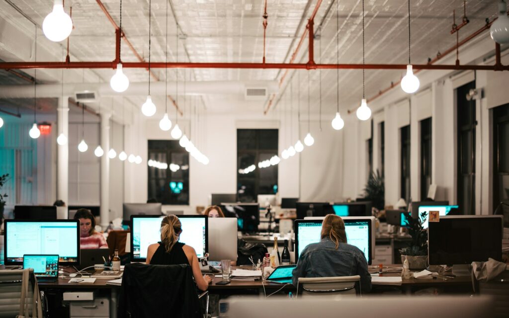 Team arbeitet an Computern im Büro, Symbolbild zu Gehaltsbänder