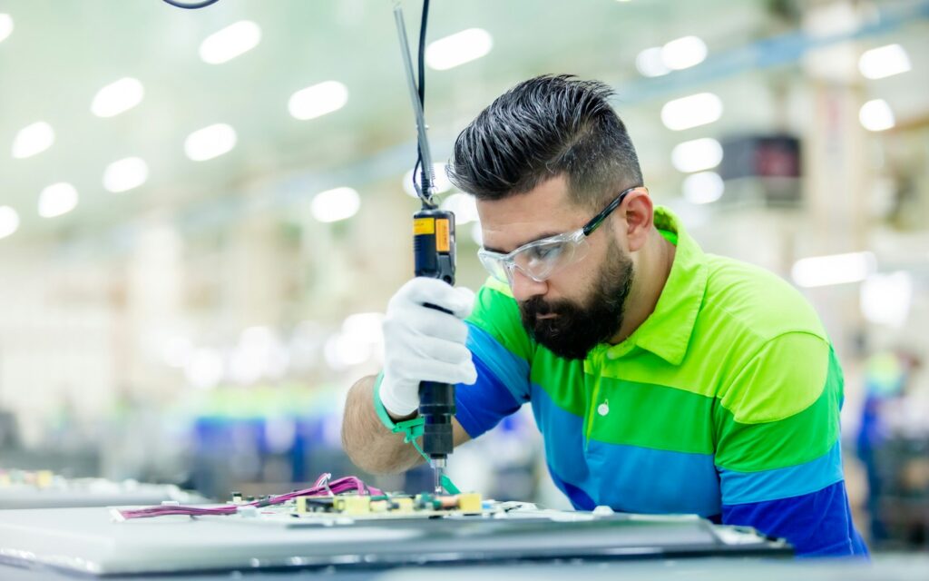 Mitarbeiter arbeitet in einer Fabrik an einer Maschine, Symbolbild zu Hidden Champions