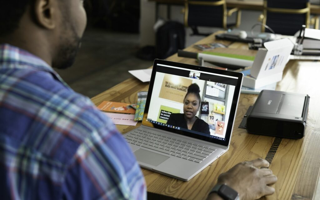 Mitarbeiter im Videocall am Laptop, um hybride Teams führen und erreichen zu können