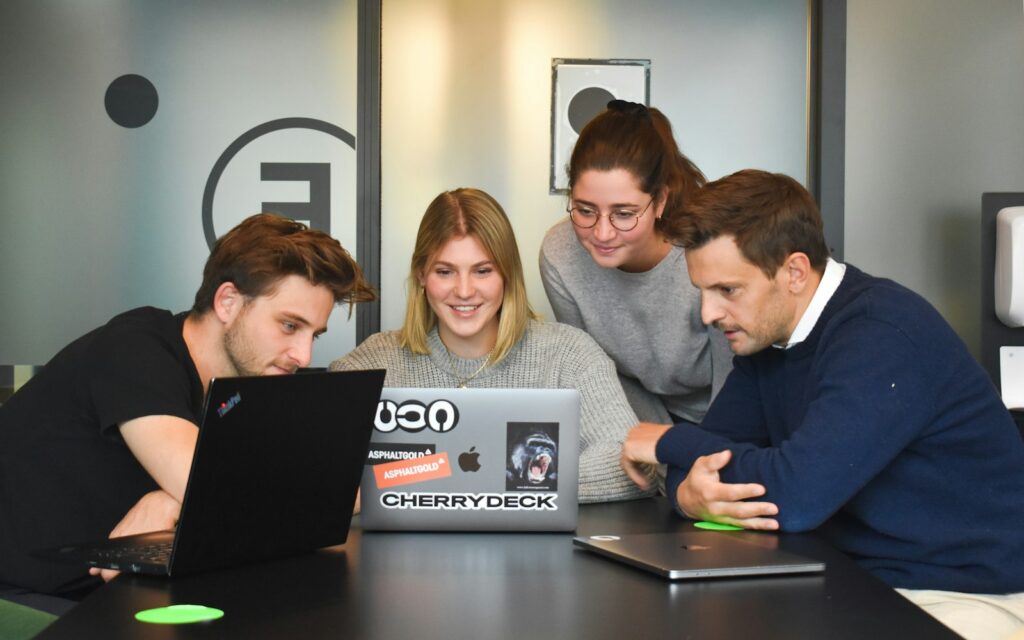 Internationales Team arbeitet am Laptop, Symbolbild zu IT-Fachkräfte aus dem Ausland