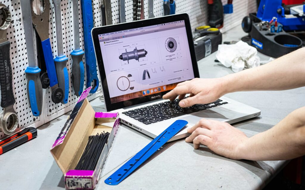 Mitarbeiter arbeitet am Laptop in der Werkstatt: KI im Mittelstand unterstützt die tägliche Arbeit