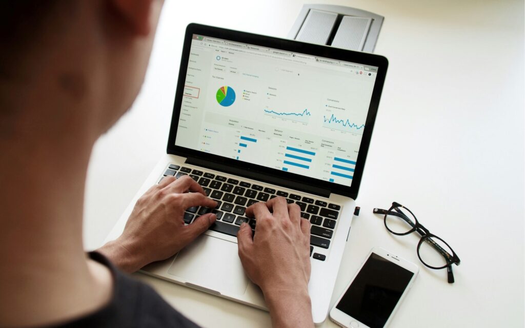 Person analysiert Zahlen am Laptop, Symbolbild zu KI-Kosten berechnen