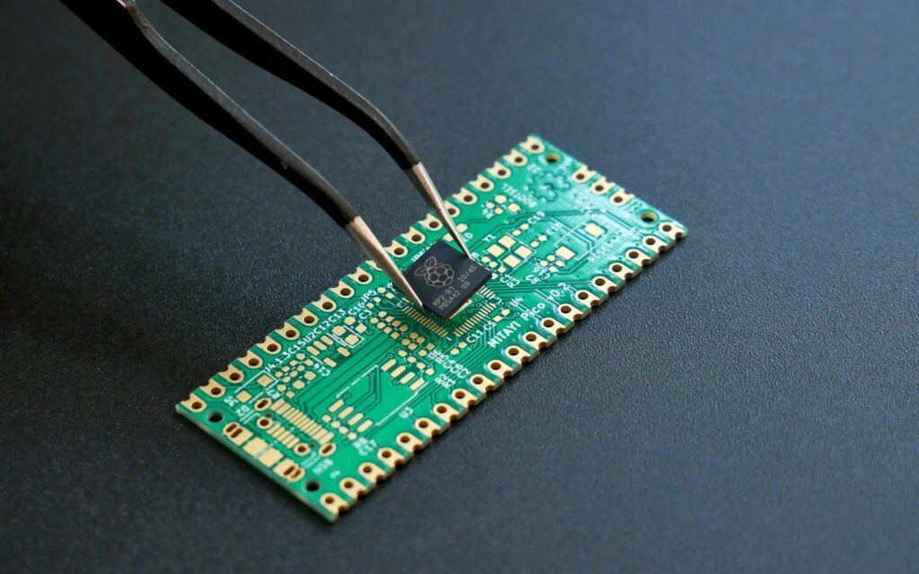 Pinzette setzt einen Mikrochip auf eine Platine: Open-Source-Firmware steuert die Hardware