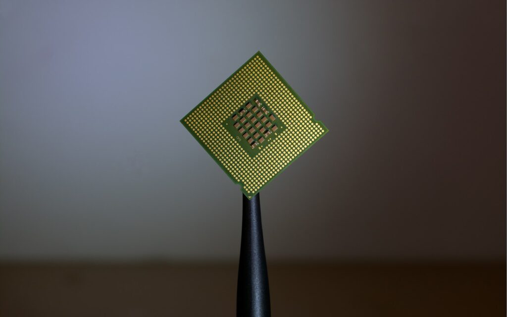 Prozessor in einer Pinzette als Symbol für Quantencomputing in Unternehmen