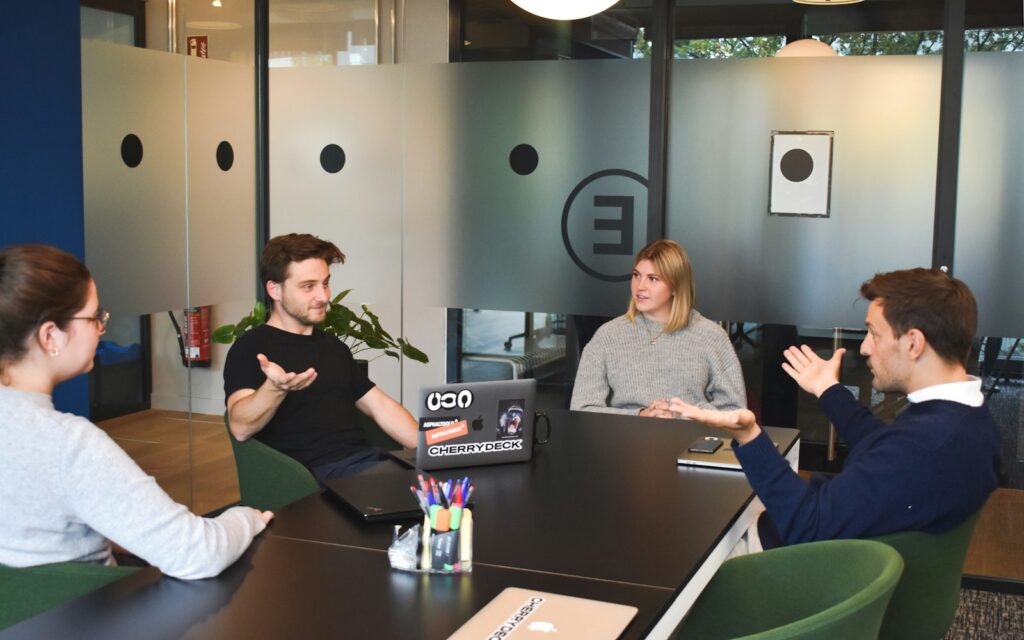 Vier Personen in einer Besprechung im modernen Büro, Symbolbild zu Revenue Operations