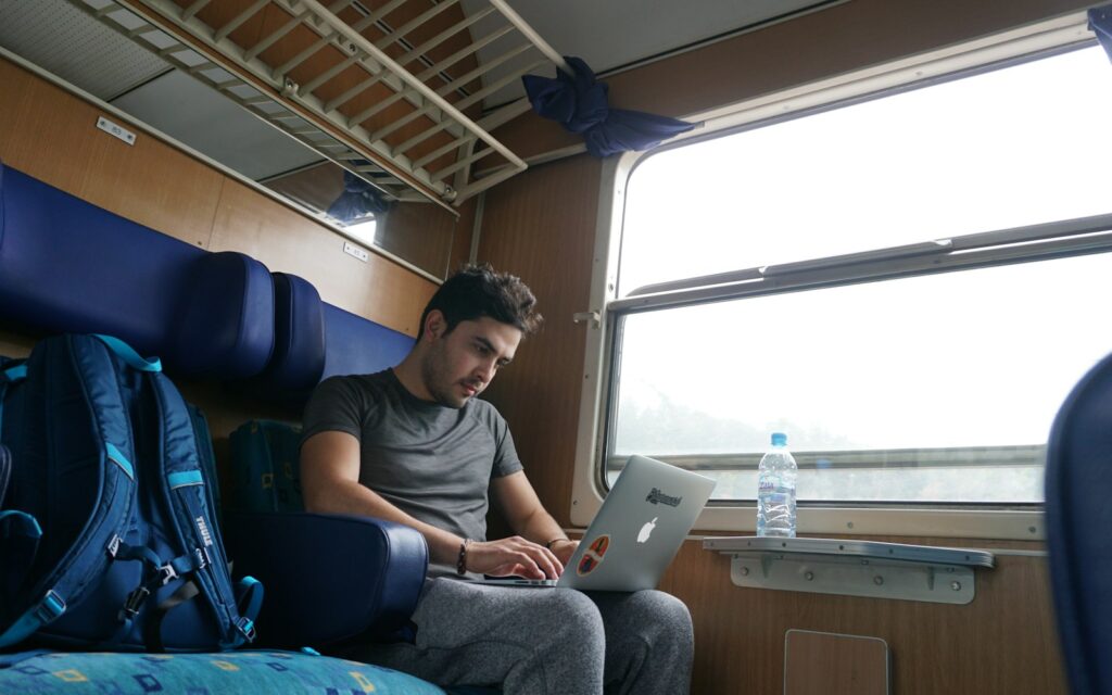 Mann arbeitet im Zug am Laptop, Symbolbild zu Thin Client oder Laptop