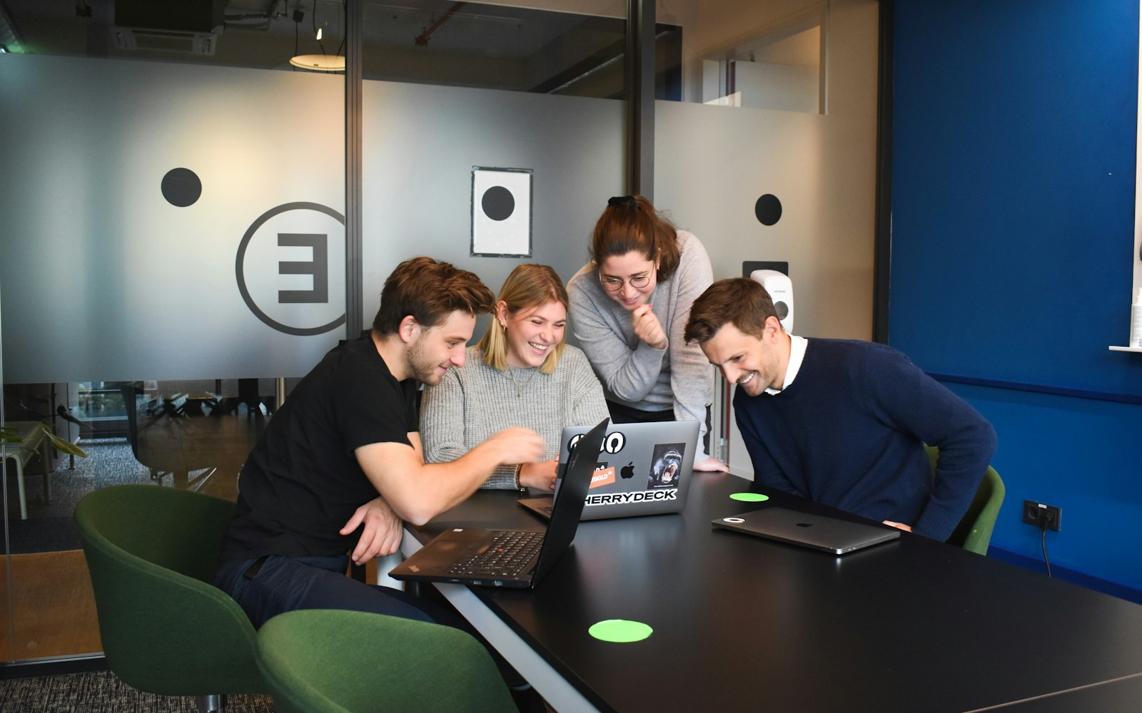 Team arbeitet an Laptops im Büro und testet die Vier-Tage-Woche im Arbeitsalltag