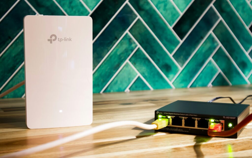 WLAN-Router und Netzwerk-Switch nebeneinander: Infrastruktur für Wi-Fi 7 im Büro